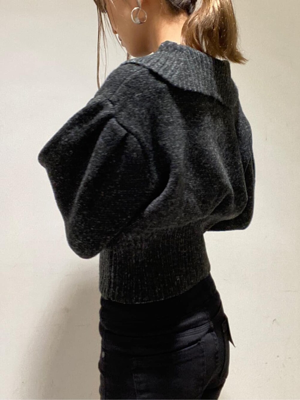 ブラック系のローファー、ブラック系のニット/セーター、ブラック系のデニムパンツを着用したレディースの冬コーディネートの4枚目の写真