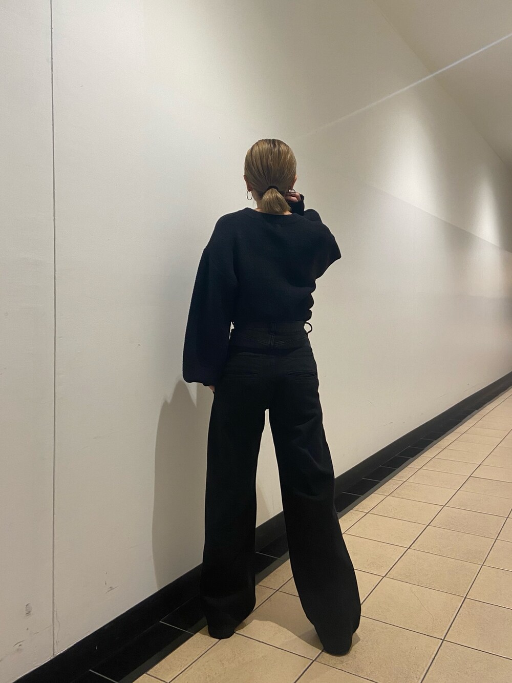 ブラック系のブーツ、ブルー系のニット/セーター、ブラック系のデニムパンツを着用したレディースの冬コーディネートの4枚目の写真