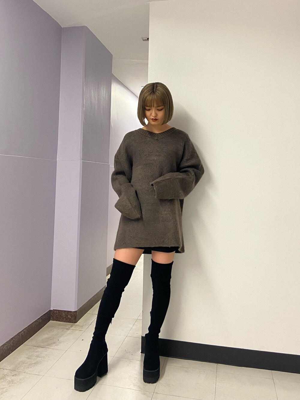 ブラウン系のニット/セーター、ブラック系のスカート、ブラック系のブーツを着用したレディースの冬コーディネートの2枚目の写真