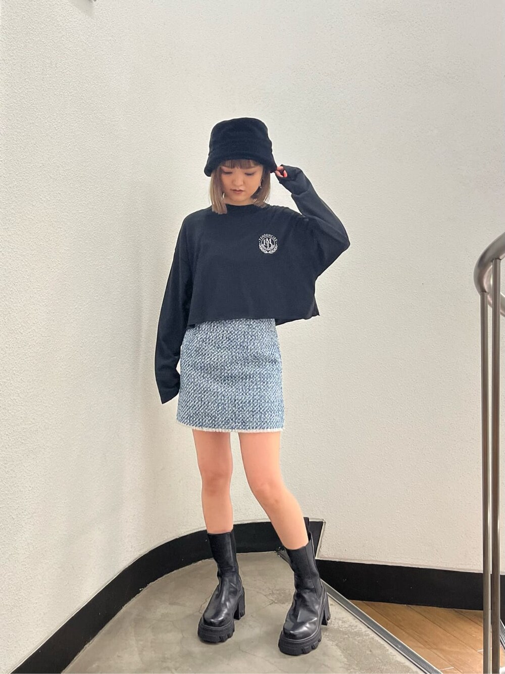ブラック系のブーツ、グレー系のスカート、ブラック系のTシャツ/カットソーを着用したレディースの秋コーディネートの2枚目の写真