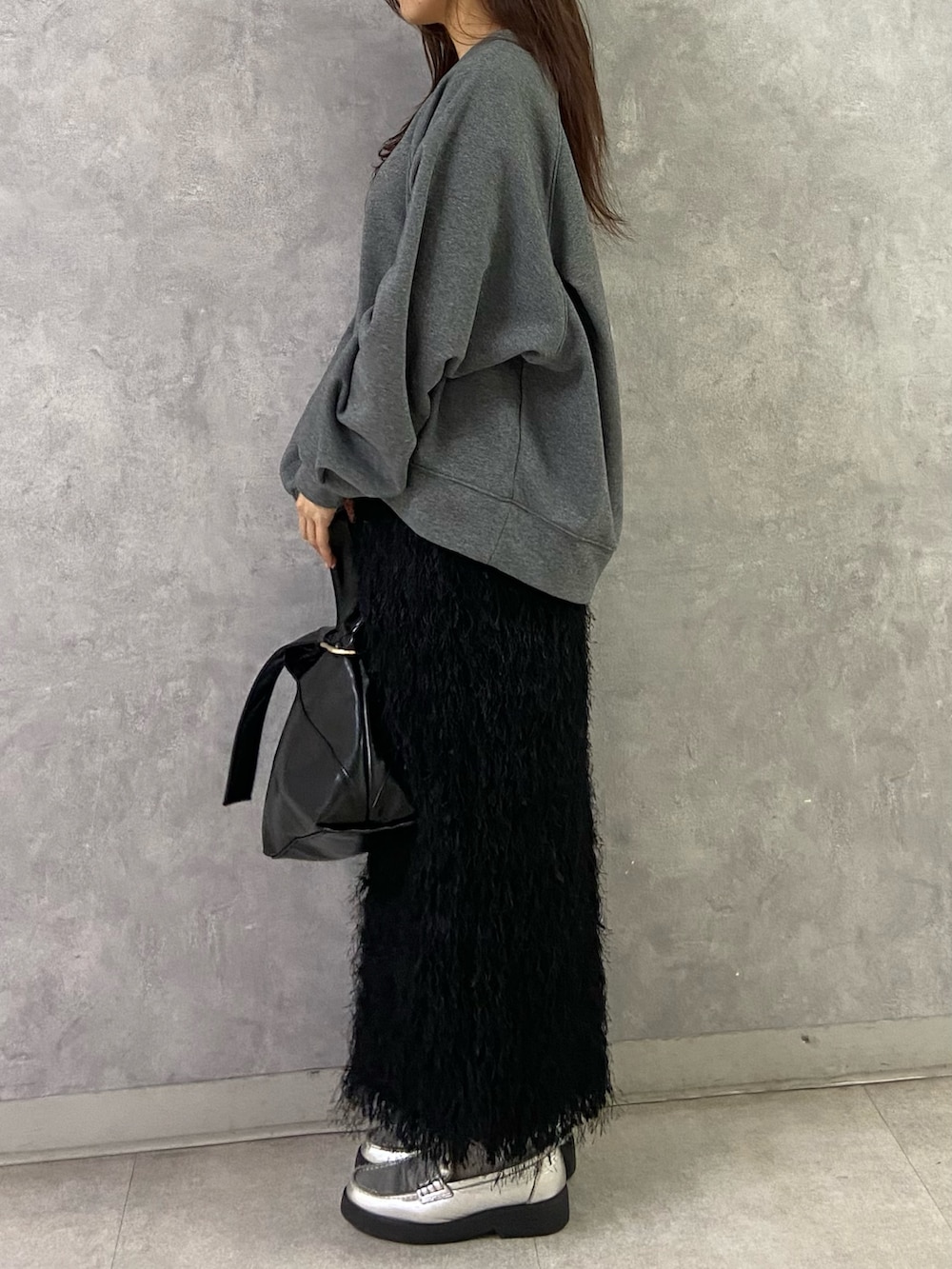 グレー系のTシャツ/カットソー、ブラック系のスカート、シルバー系のローファーを着用したレディースの冬コーディネートの3枚目の写真