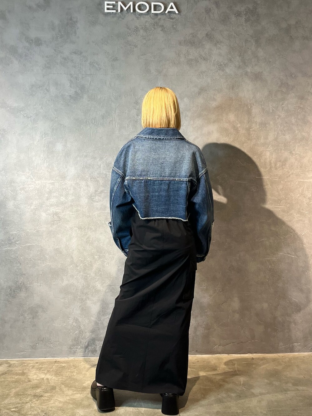 ブルー系のデニムジャケット、ベージュ系のキャミソール、ブラック系のスカートを着用したレディースの春コーディネートの3枚目の写真