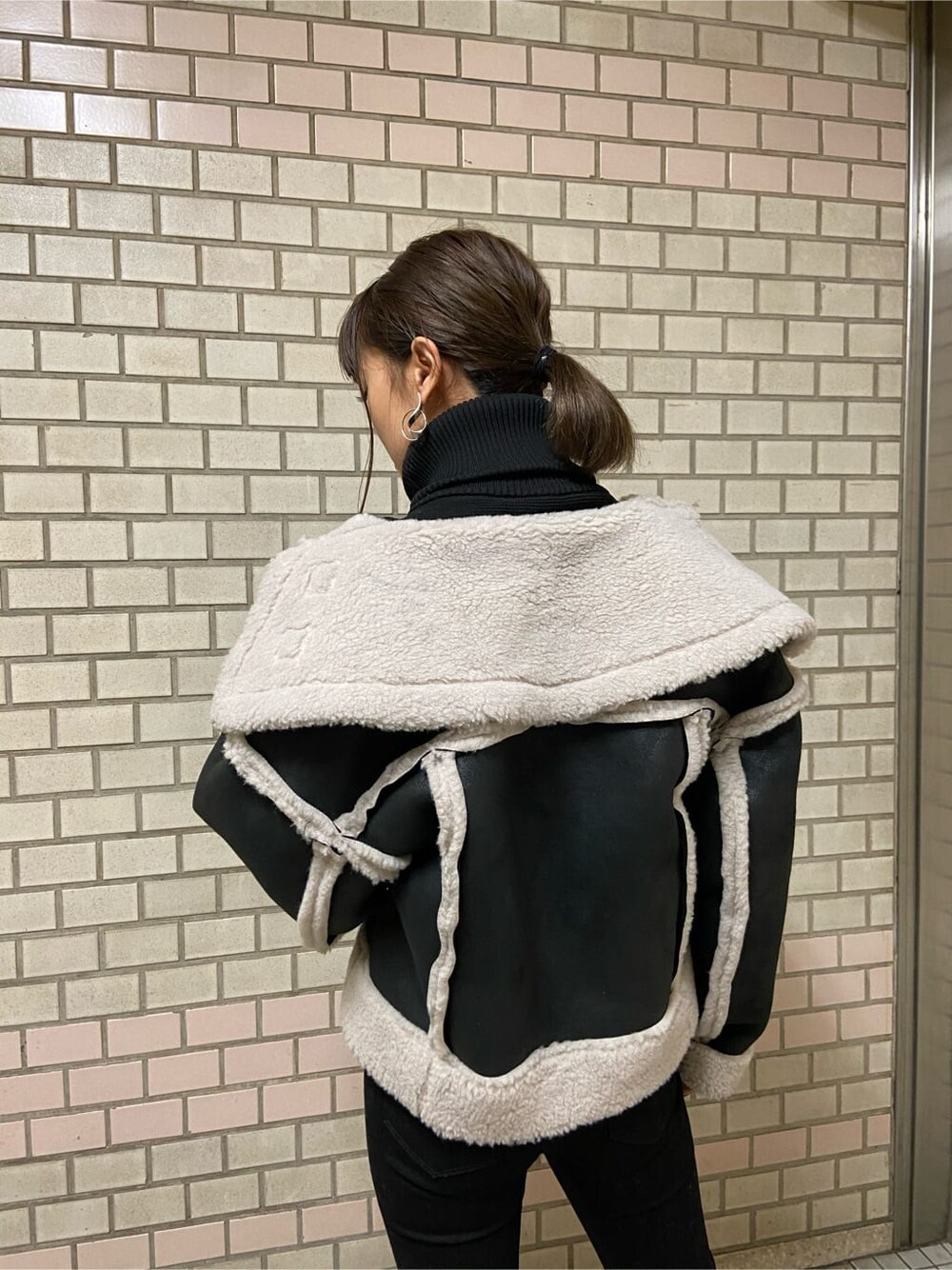 その他のムートンコート、ブラック系のブーツ、ブラック系のニット/セーターを着用したレディースの秋コーディネートの4枚目の写真