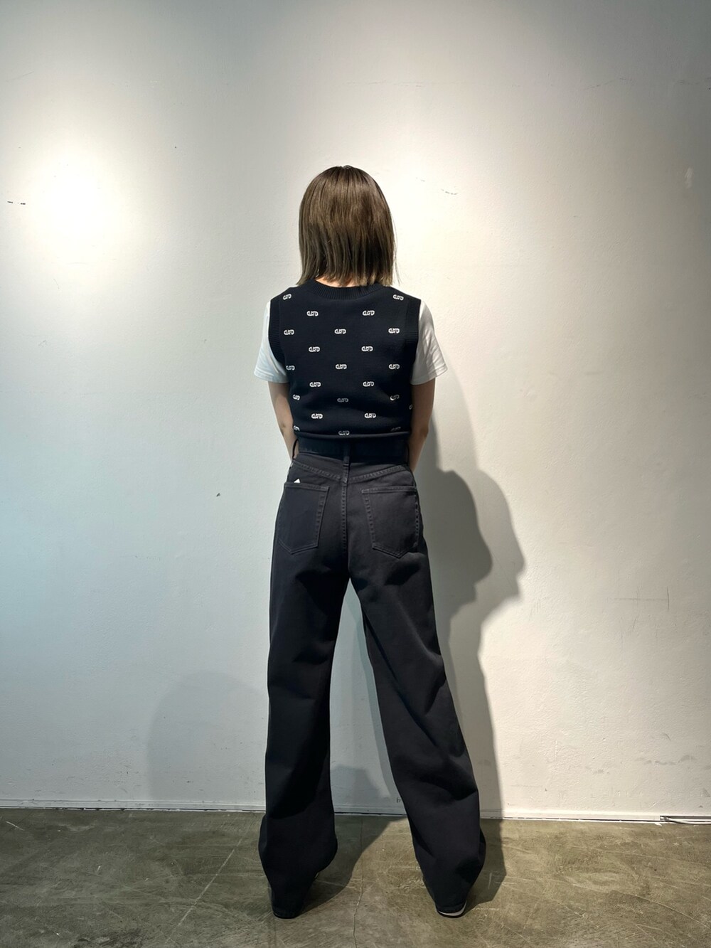 ホワイト系のTシャツ/カットソー、ブラック系のデニムパンツ、ホワイト系のサンダルを着用したレディースの春コーディネートの4枚目の写真