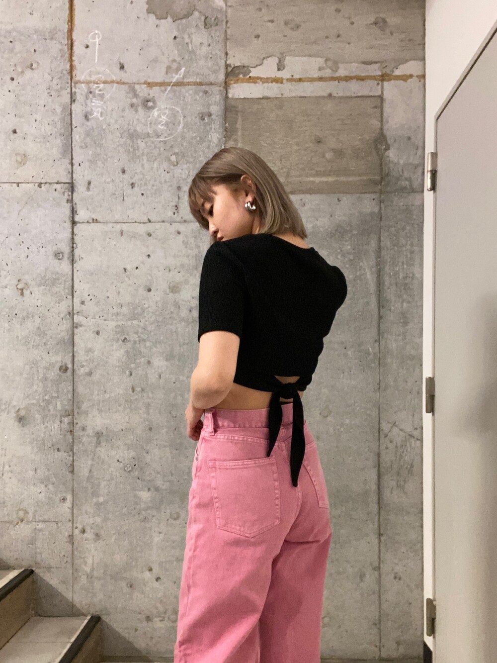 ブラック系のTシャツ/カットソー、ピンク系のデニムパンツ、ブラック系のサンダルを着用したレディースの春コーディネートの4枚目の写真