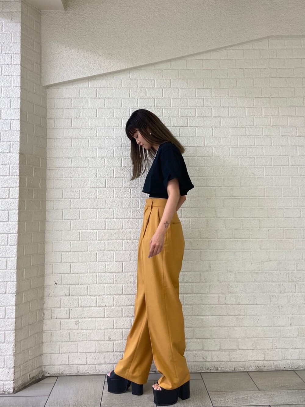 ブラック系のサンダル、オレンジ系のその他パンツ、ブラック系のTシャツ/カットソーを着用したレディースの春コーディネートの2枚目の写真