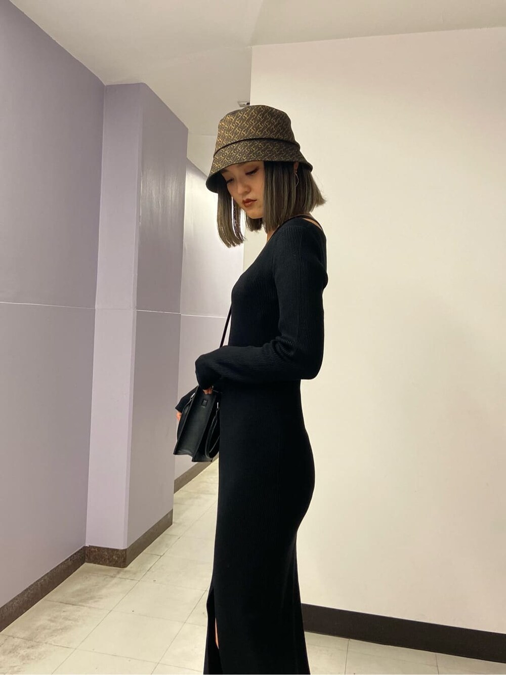 ブラック系のワンピース、ブラック系のブーツ、ブラック系のハンドバッグを着用したレディースの秋コーディネートの5枚目の写真