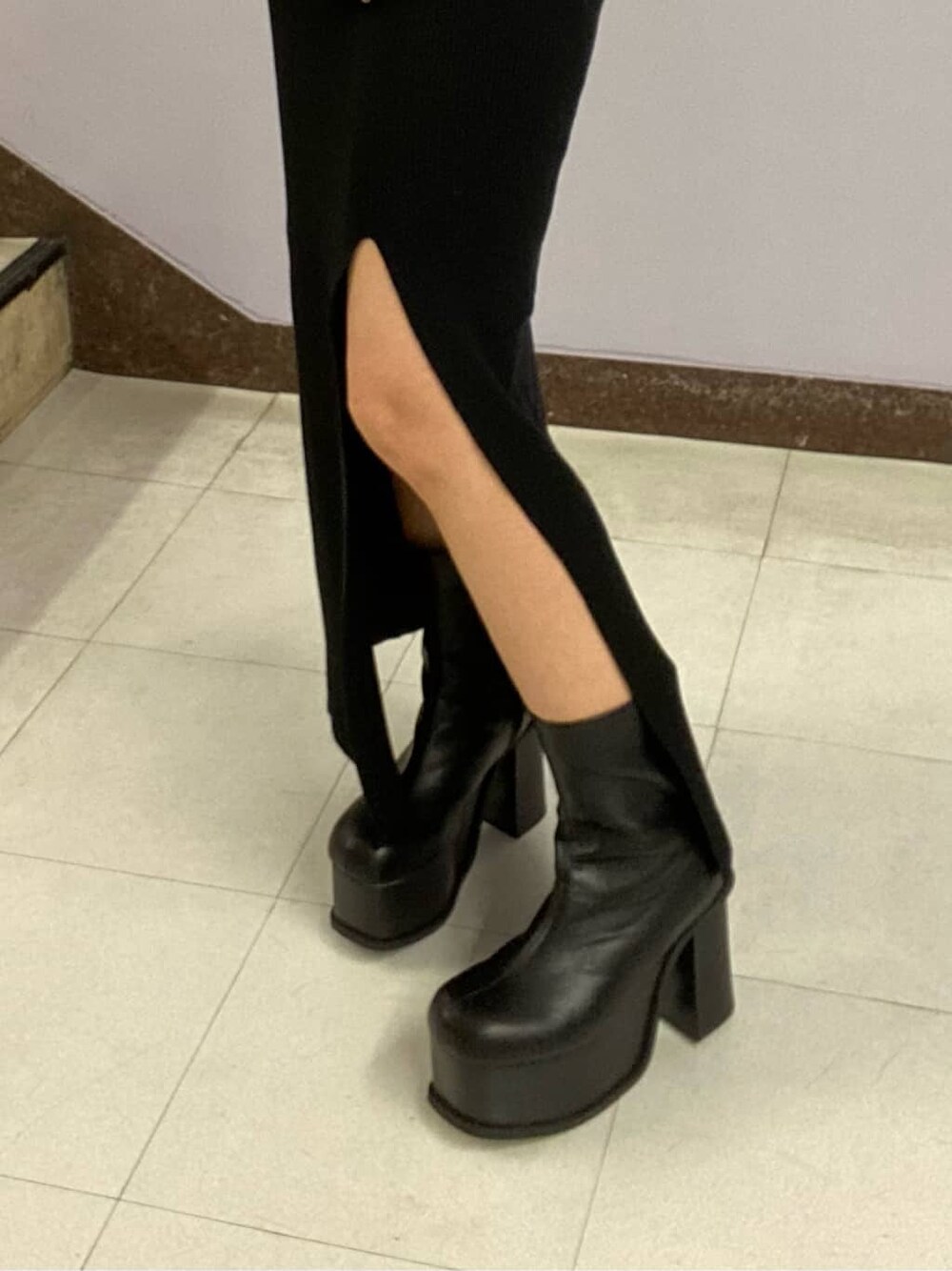 ブラック系のワンピース、ブラック系のブーツ、ブラック系のハンドバッグを着用したレディースの秋コーディネートの6枚目の写真