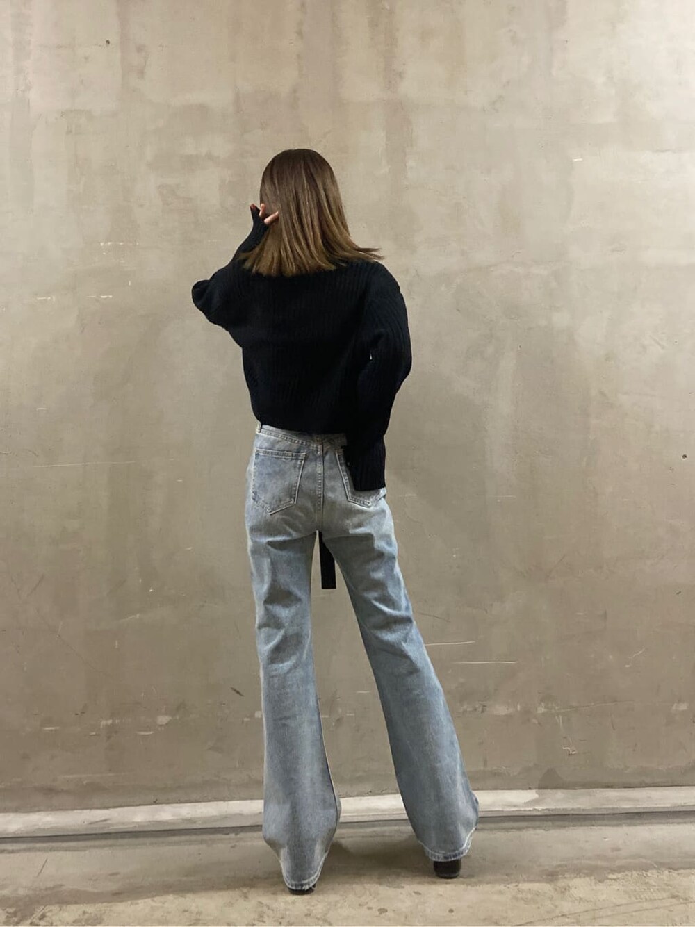 ブルー系のデニムパンツ、ブラック系のローファー、ブラック系のニット/セーターを着用したレディースの春コーディネートの3枚目の写真