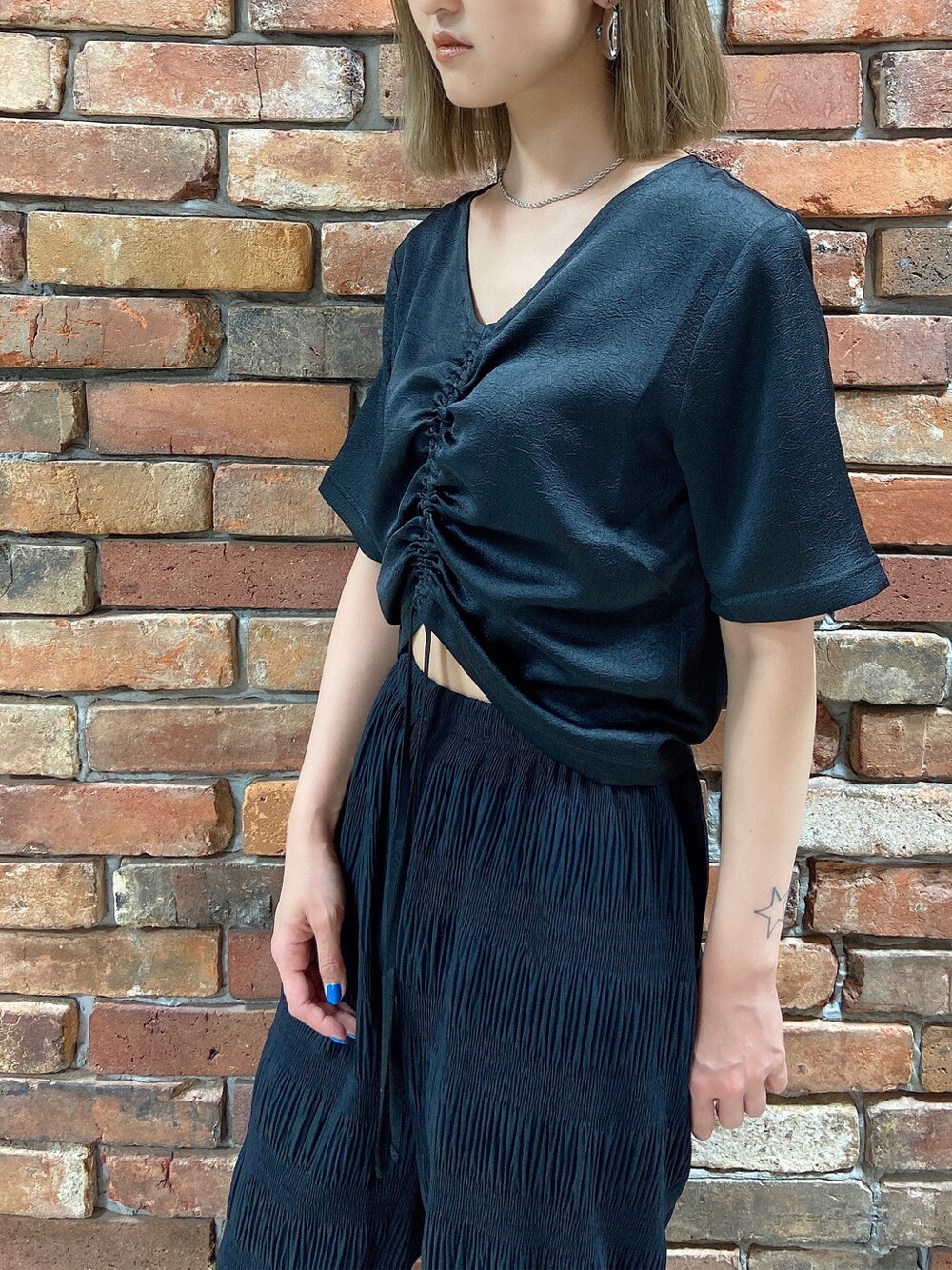 ブラック系のその他パンツ、ホワイト系のショルダーバッグ、ブラック系のTシャツ/カットソーを着用したレディースの春コーディネートの2枚目の写真