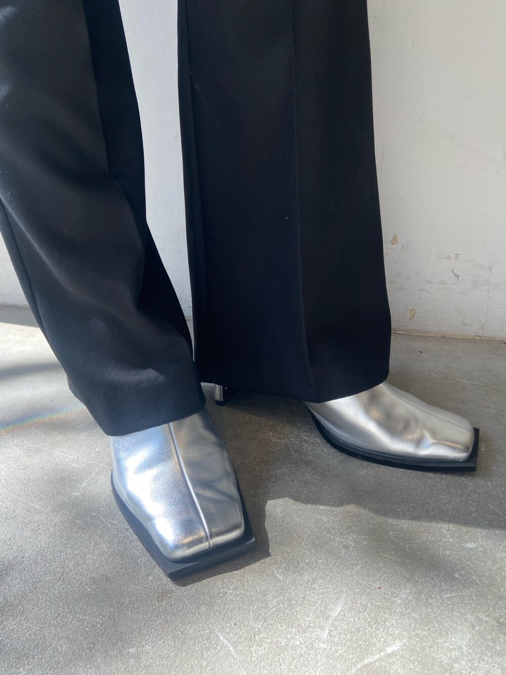 グレー系のパーカー、ブラック系のその他パンツ、シルバー系のサンダルを着用したレディースの秋コーディネートの4枚目の写真