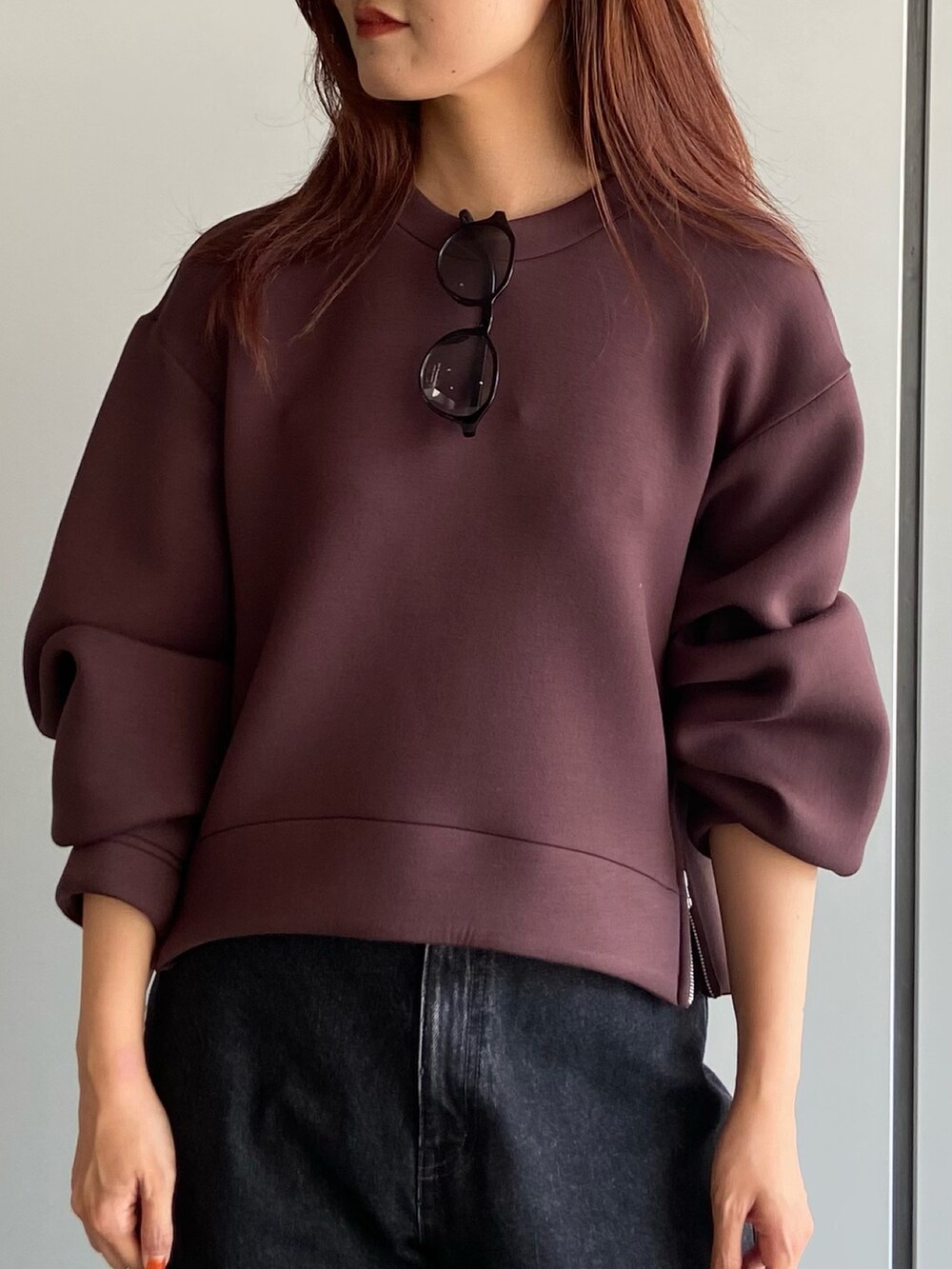 ブラウン系のスウェット、ブラック系のデニムパンツ、ブラック系のローファーを着用したレディースの夏コーディネートの5枚目の写真