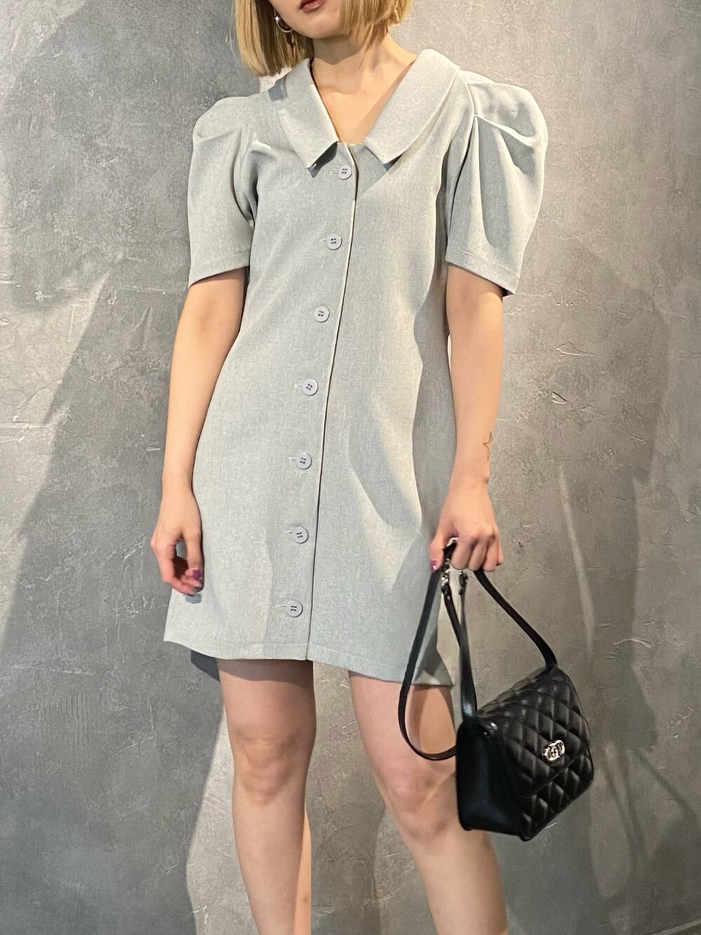 グレー系のワンピース、ブラック系のショルダーバッグ、ブラック系のサンダルを着用したレディースの春コーディネートの5枚目の写真