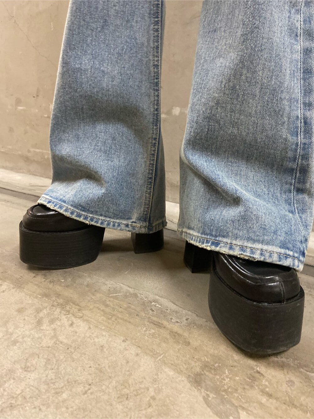 ブルー系のデニムパンツ、ブラック系のローファー、ブラック系のニット/セーターを着用したレディースの春コーディネートの7枚目の写真