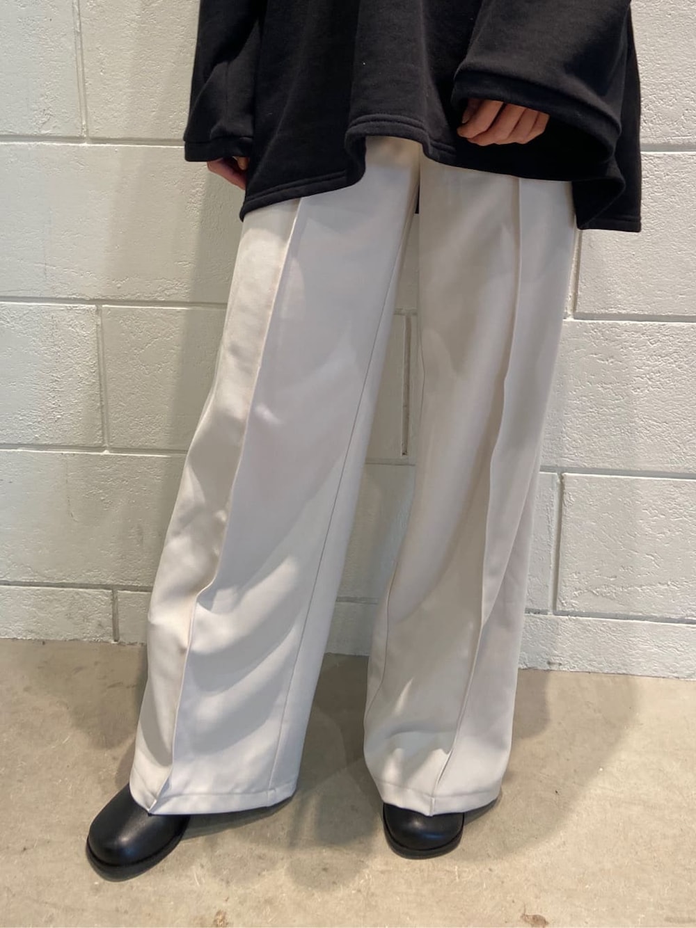 ホワイト系のその他パンツ、ブラック系のブーツ、ブラック系のTシャツ/カットソーを着用したレディースの春コーディネートの6枚目の写真