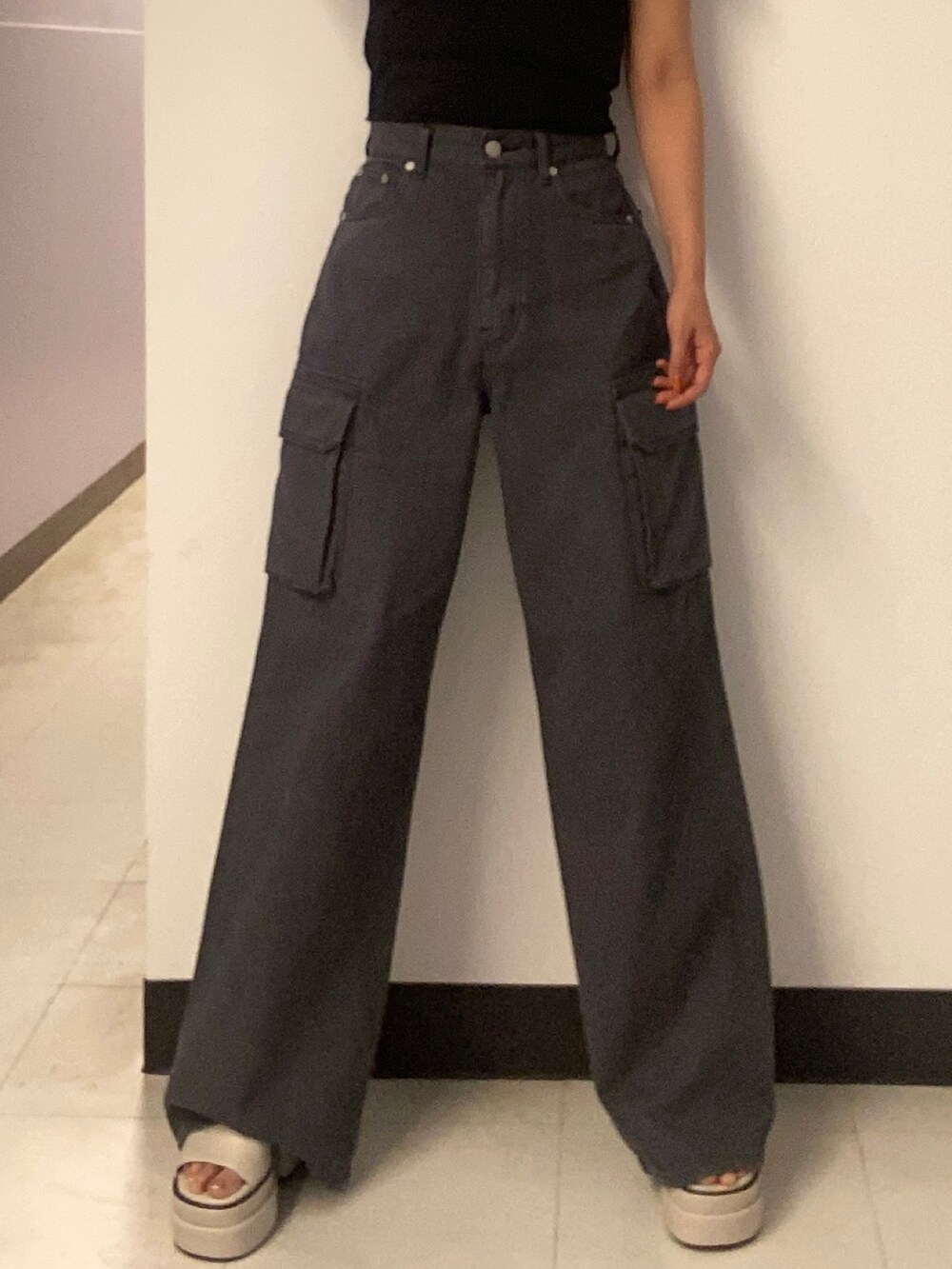 ブラック系のTシャツ/カットソー、ブラック系のデニムパンツ、ホワイト系のサンダルを着用したレディースの春コーディネートの4枚目の写真