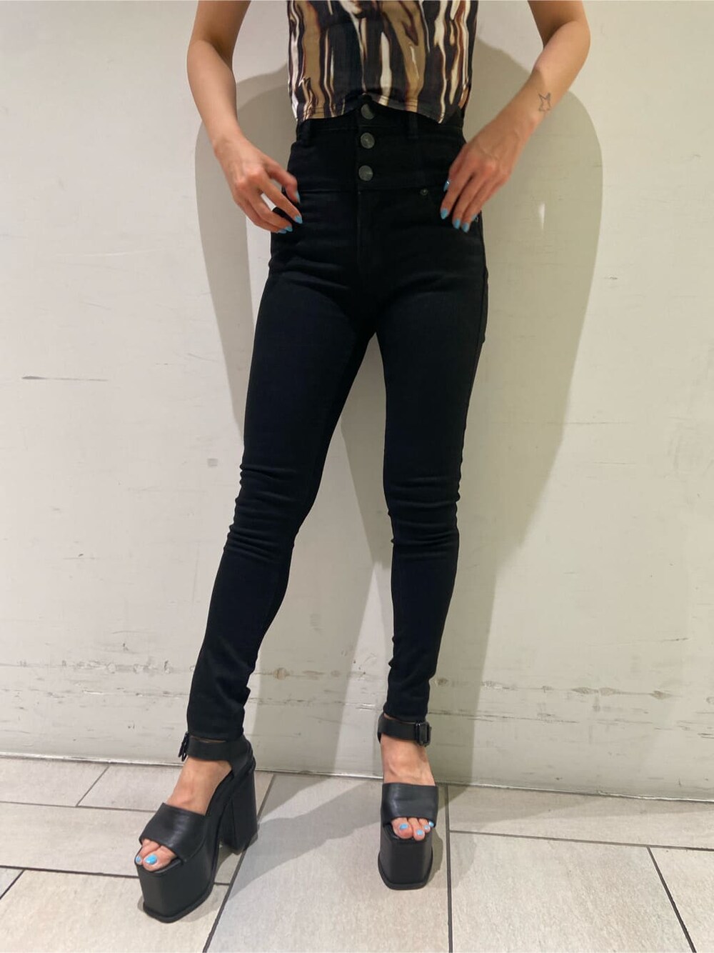 ブラック系のデニムパンツ、ブラック系のサンダル、その他のTシャツ/カットソーを着用したレディースの夏コーディネートの6枚目の写真