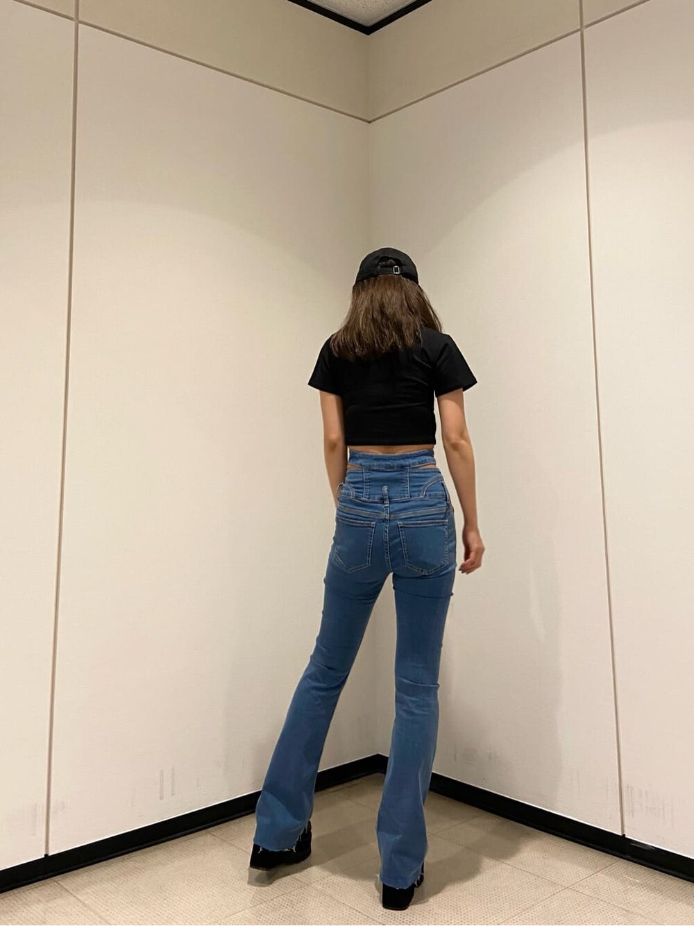 ブルー系のデニムパンツ、ブラック系のサンダル、ブラック系のTシャツ/カットソーを着用したレディースの夏コーディネートの3枚目の写真