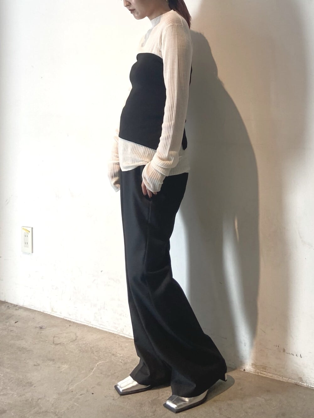 ブラック系のその他パンツ、シルバー系のサンダル、ホワイト系のニット/セーターを着用したレディースの冬コーディネートの2枚目の写真