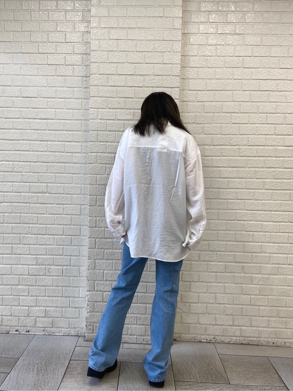 ブルー系のデニムパンツ、ブラック系のサンダル、ホワイト系のシャツ/ブラウスを着用したレディースの夏コーディネートの3枚目の写真