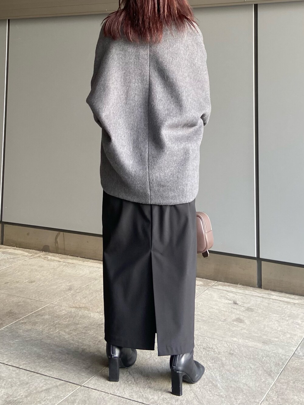 ブラック系のスカート、ブラウン系のボストンバッグ、ブラック系のブーツを着用したレディースの冬コーディネートの3枚目の写真