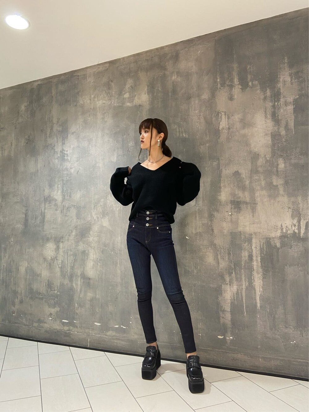 ブラック系のローファー、ブルー系のデニムパンツ、ブラック系のニット/セーターを着用したレディースの秋コーディネートの6枚目の写真