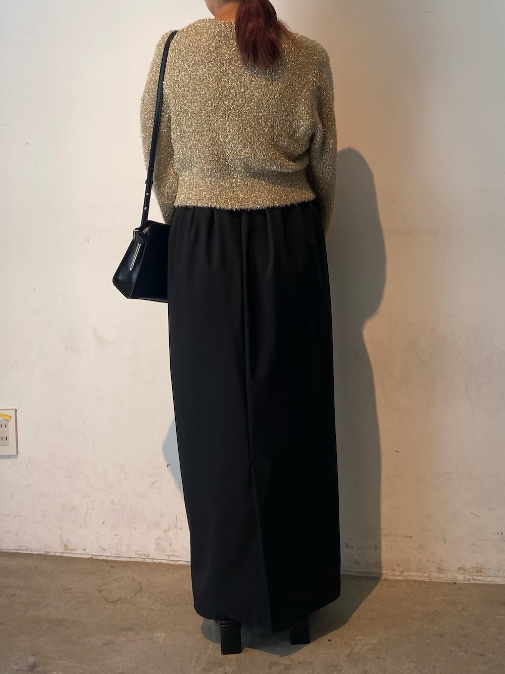 ゴールド系のカーディガン/ボレロ、ブラック系のスカート、ブラック系のサンダルを着用したレディースの冬コーディネートの3枚目の写真
