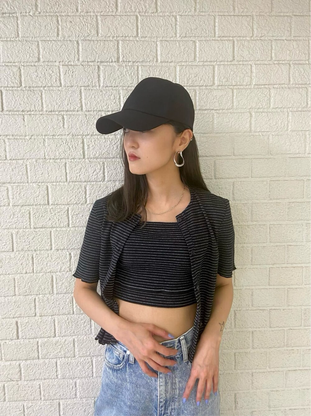 ブラック系のサンダル、ブルー系のデニムパンツ、その他のアンサンブルを着用したレディースの夏コーディネートの3枚目の写真