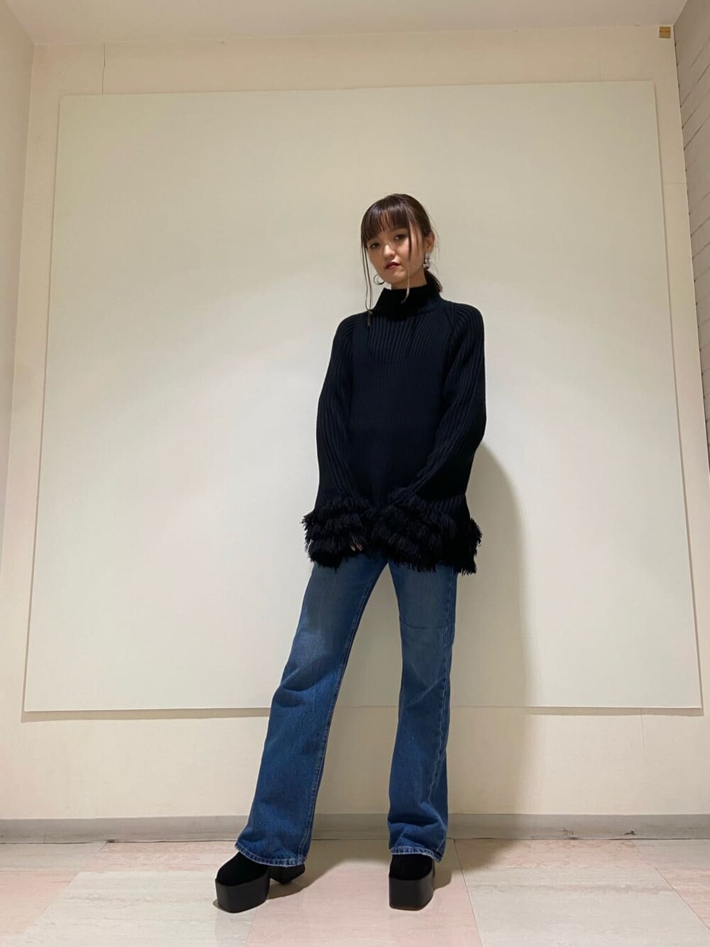 ブラック系のブーツ、ブルー系のデニムパンツ、ブラック系のニット/セーターを着用したレディースの冬コーディネートの5枚目の写真
