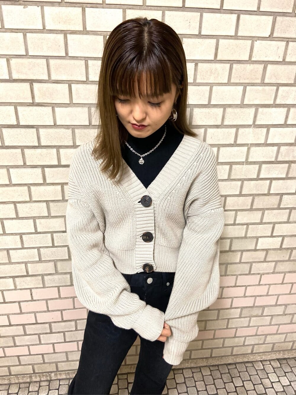 ブラック系のローファー、ブラック系のニット/セーター、ベージュ系のカーディガン/ボレロを着用したレディースの冬コーディネートの4枚目の写真