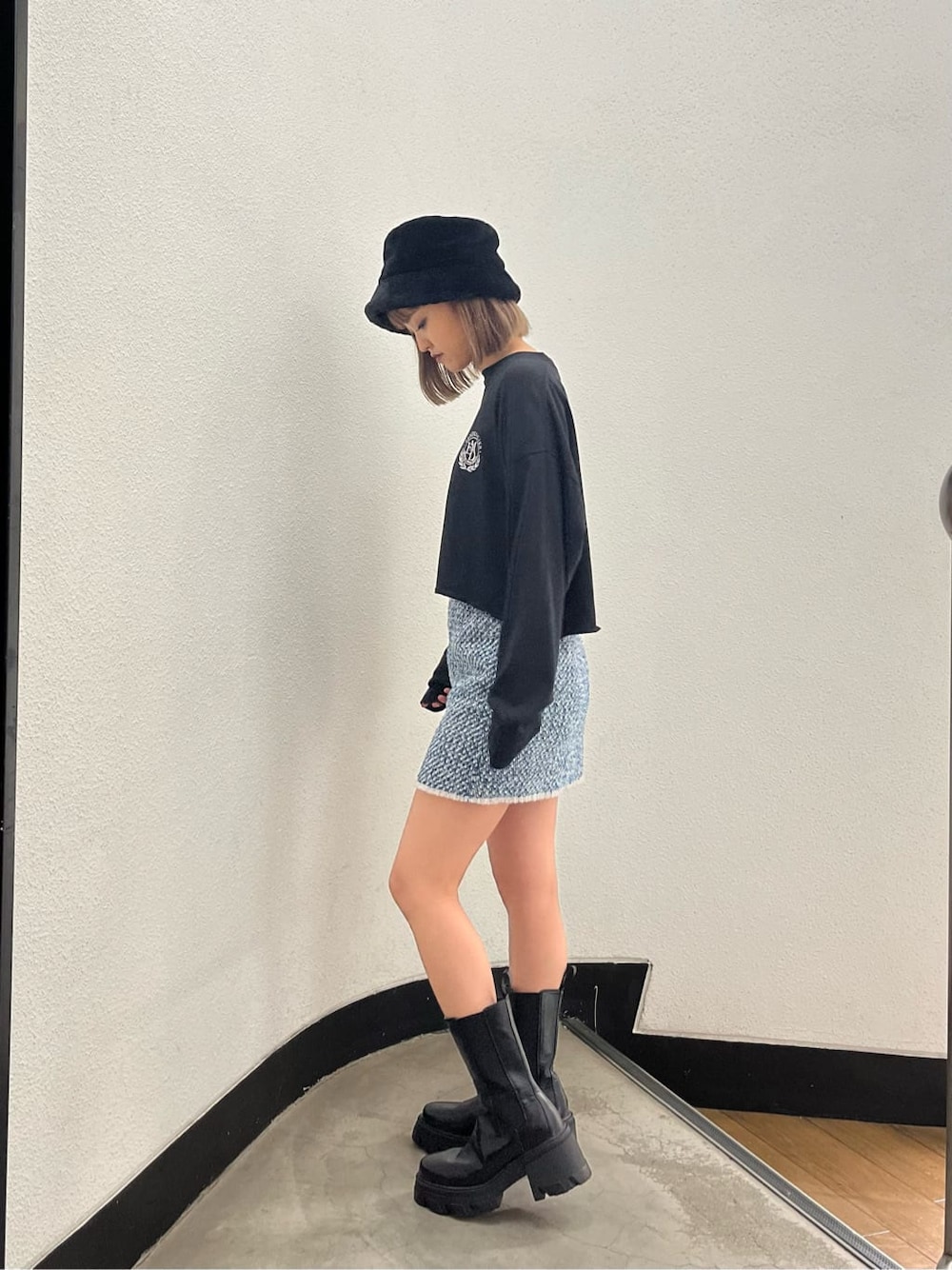 ブラック系のブーツ、グレー系のスカート、ブラック系のTシャツ/カットソーを着用したレディースの秋コーディネートの3枚目の写真