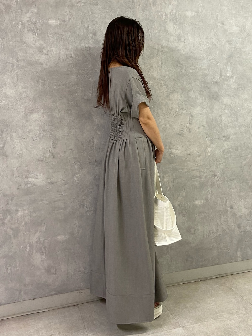 ホワイト系のサンダル、ベージュ系のワンピースを着用したレディースの春コーディネートの3枚目の写真