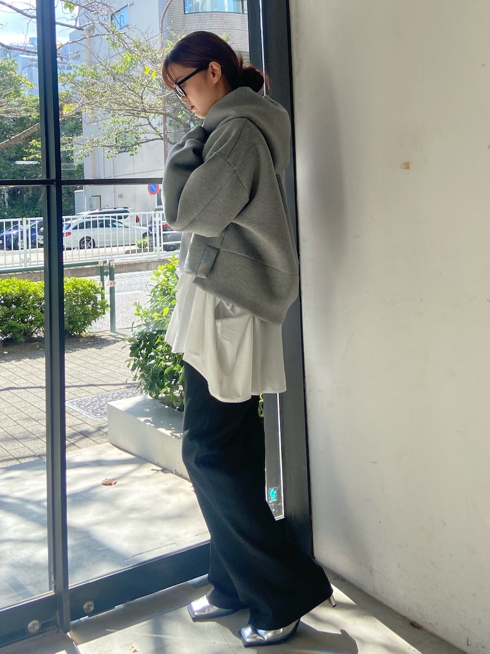 グレー系のパーカー、ブラック系のその他パンツ、シルバー系のサンダルを着用したレディースの秋コーディネートの2枚目の写真