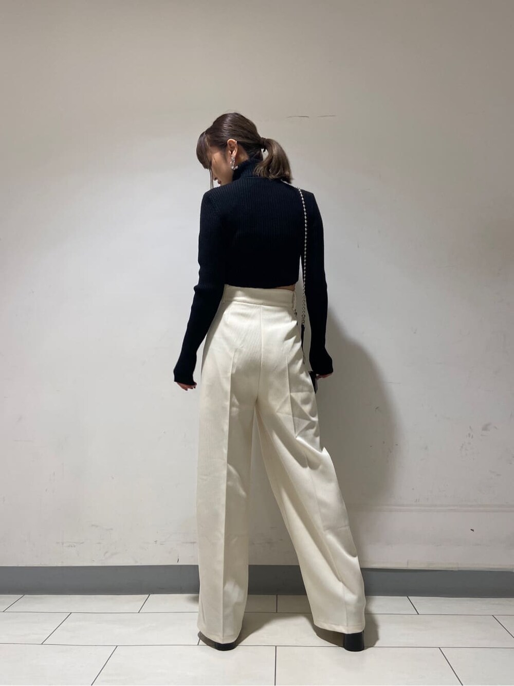 ホワイト系のその他パンツ、ブラック系のローファー、ブラック系のハンドバッグを着用したレディースの冬コーディネートの2枚目の写真