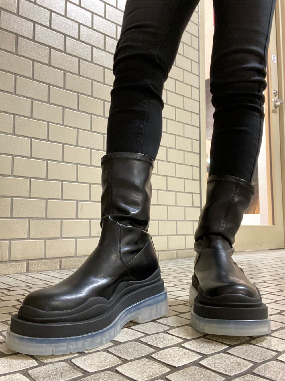 ブラック系のブーツ、ブラック系のニット/セーター、ブラック系のダウンジャケット/コートを着用したレディースの冬コーディネートの6枚目の写真