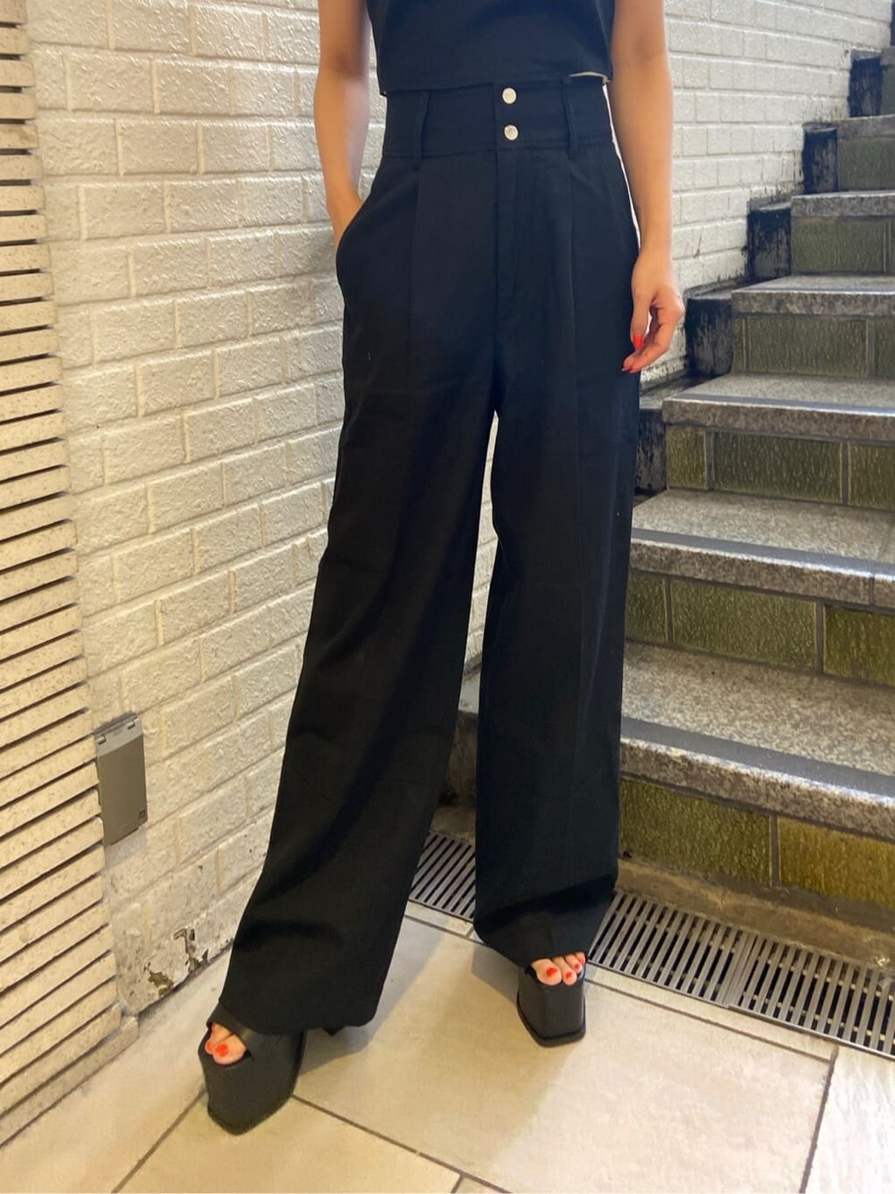 ブラック系のサンダル、ブラック系のその他パンツ、ホワイト系のTシャツ/カットソーを着用したレディースの夏コーディネートの5枚目の写真