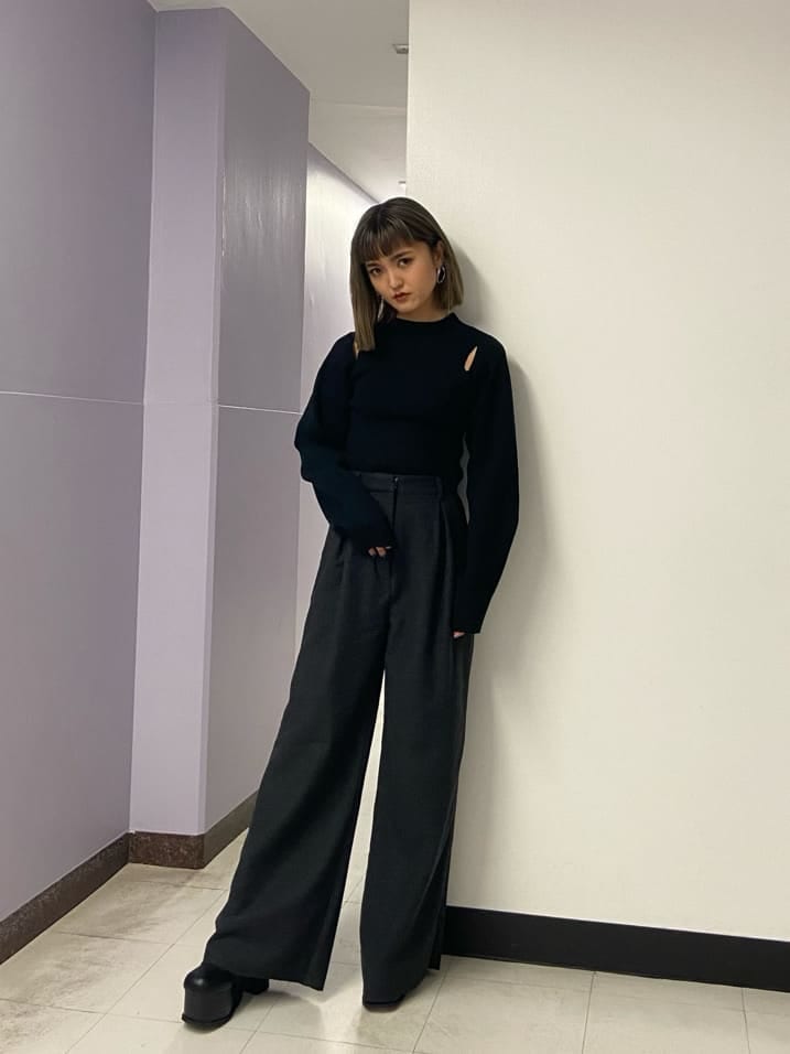 グレー系のその他パンツ、ブラック系のブーツ、ブラック系のニット/セーターを着用したレディースの秋コーディネートの2枚目の写真