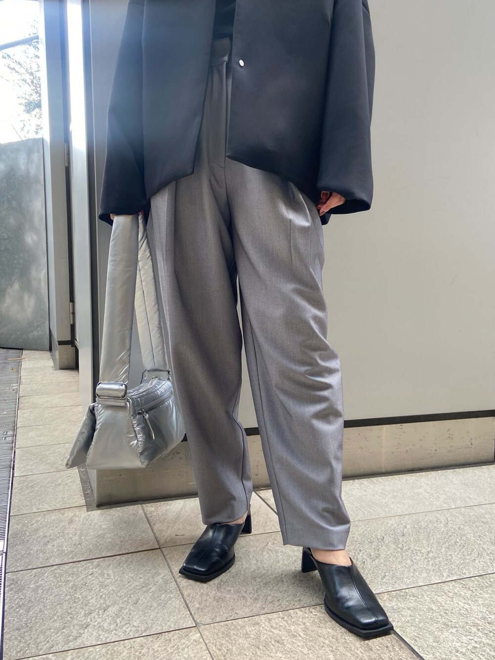 ブラック系のその他アウター、ブラック系のTシャツ/カットソー、グレー系のその他パンツを着用したレディースの冬コーディネートの6枚目の写真