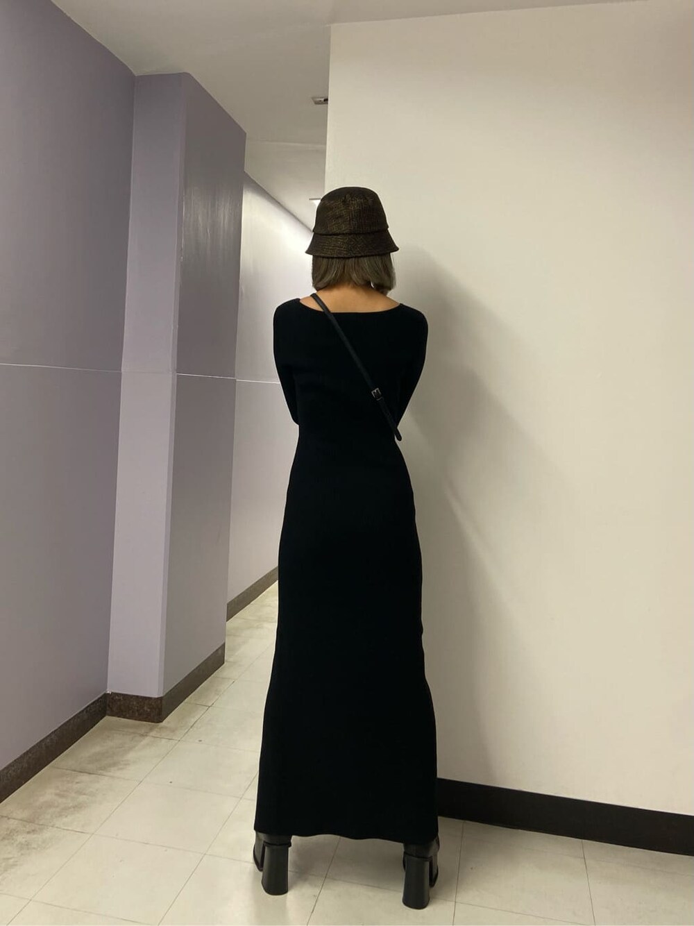 ブラック系のワンピース、ブラック系のブーツ、ブラック系のハンドバッグを着用したレディースの秋コーディネートの4枚目の写真