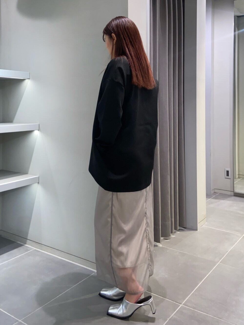 シルバー系のサンダル、ブラック系のカーディガン/ボレロ、ベージュ系のスカートを着用したレディースの冬コーディネートの2枚目の写真