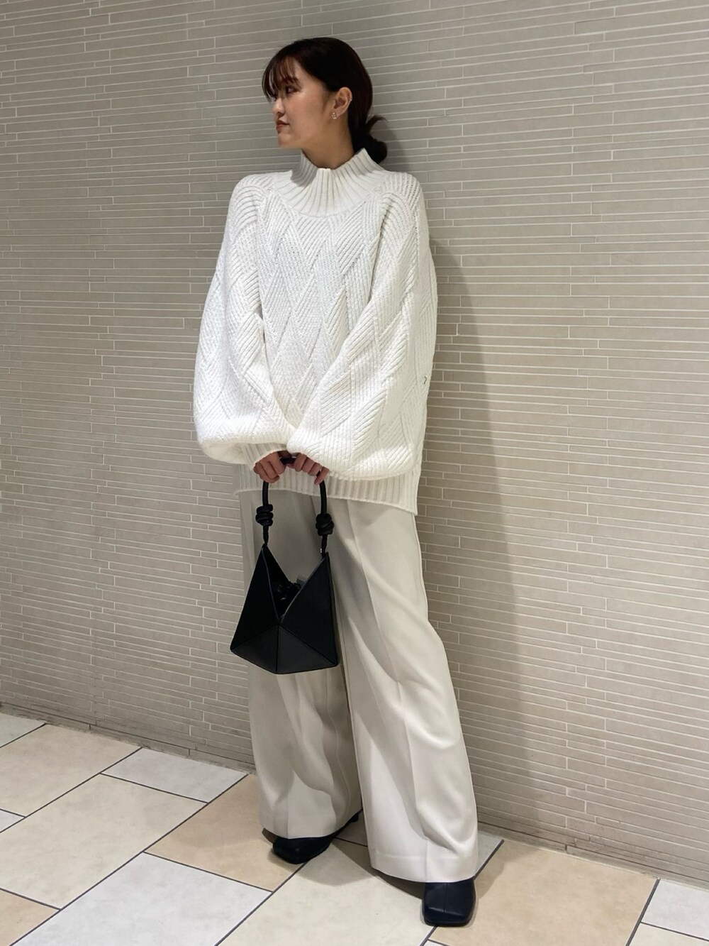 ホワイト系のニット/セーター、ホワイト系のその他パンツ、ブラック系のブーツを着用したレディースの秋コーディネートの2枚目の写真