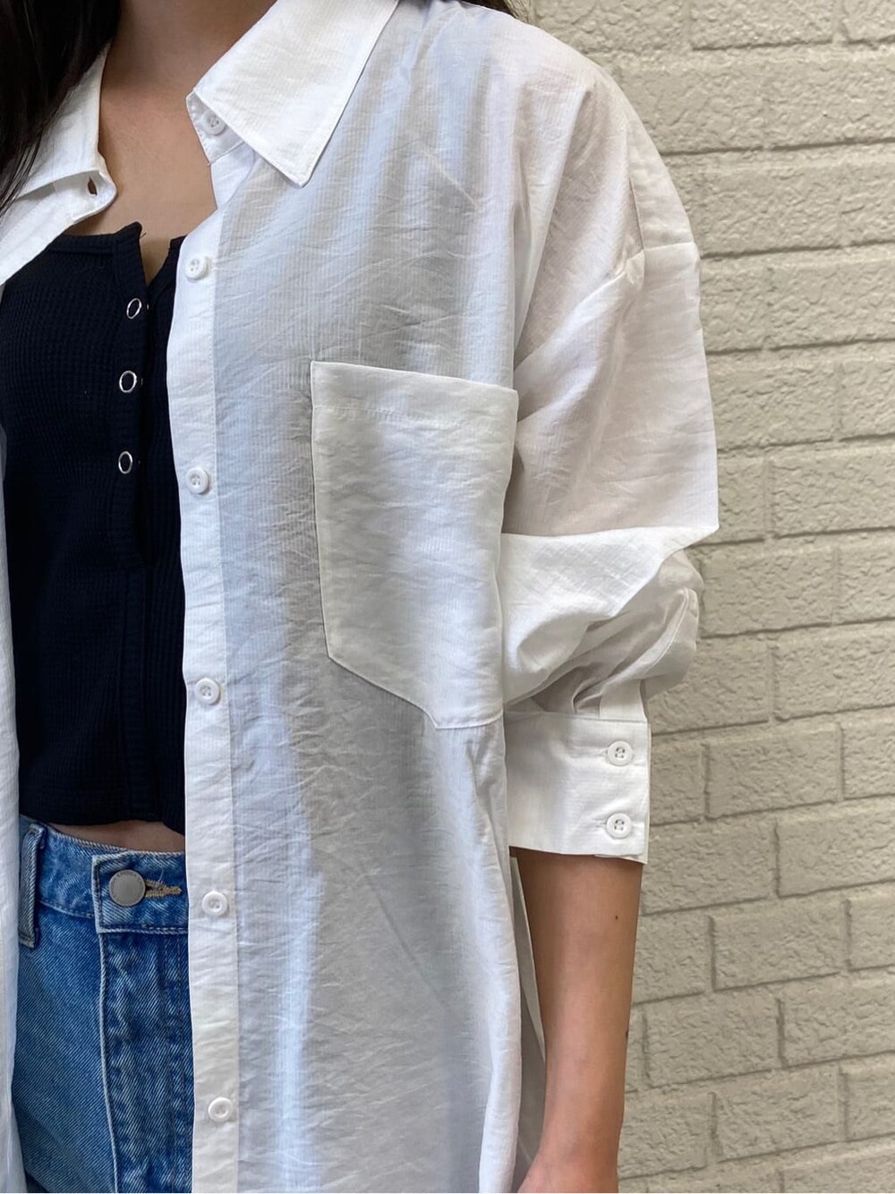 ブルー系のデニムパンツ、ブラック系のサンダル、ホワイト系のシャツ/ブラウスを着用したレディースの夏コーディネートの5枚目の写真