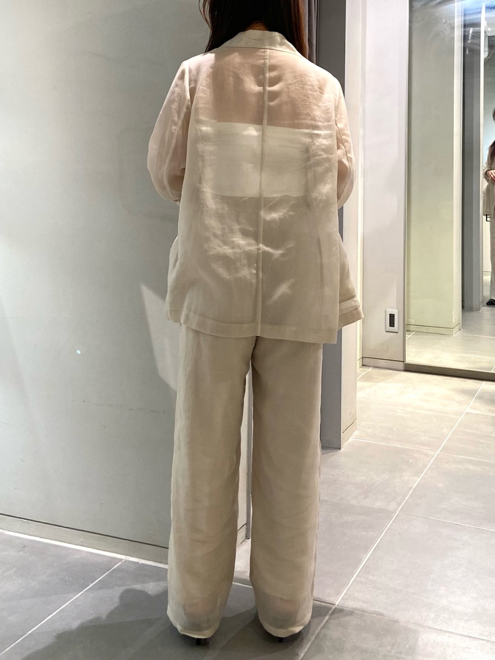 ホワイト系のテーラードジャケット、ホワイト系のその他パンツ、ブラック系のパンプスを着用したレディースの春コーディネートの4枚目の写真