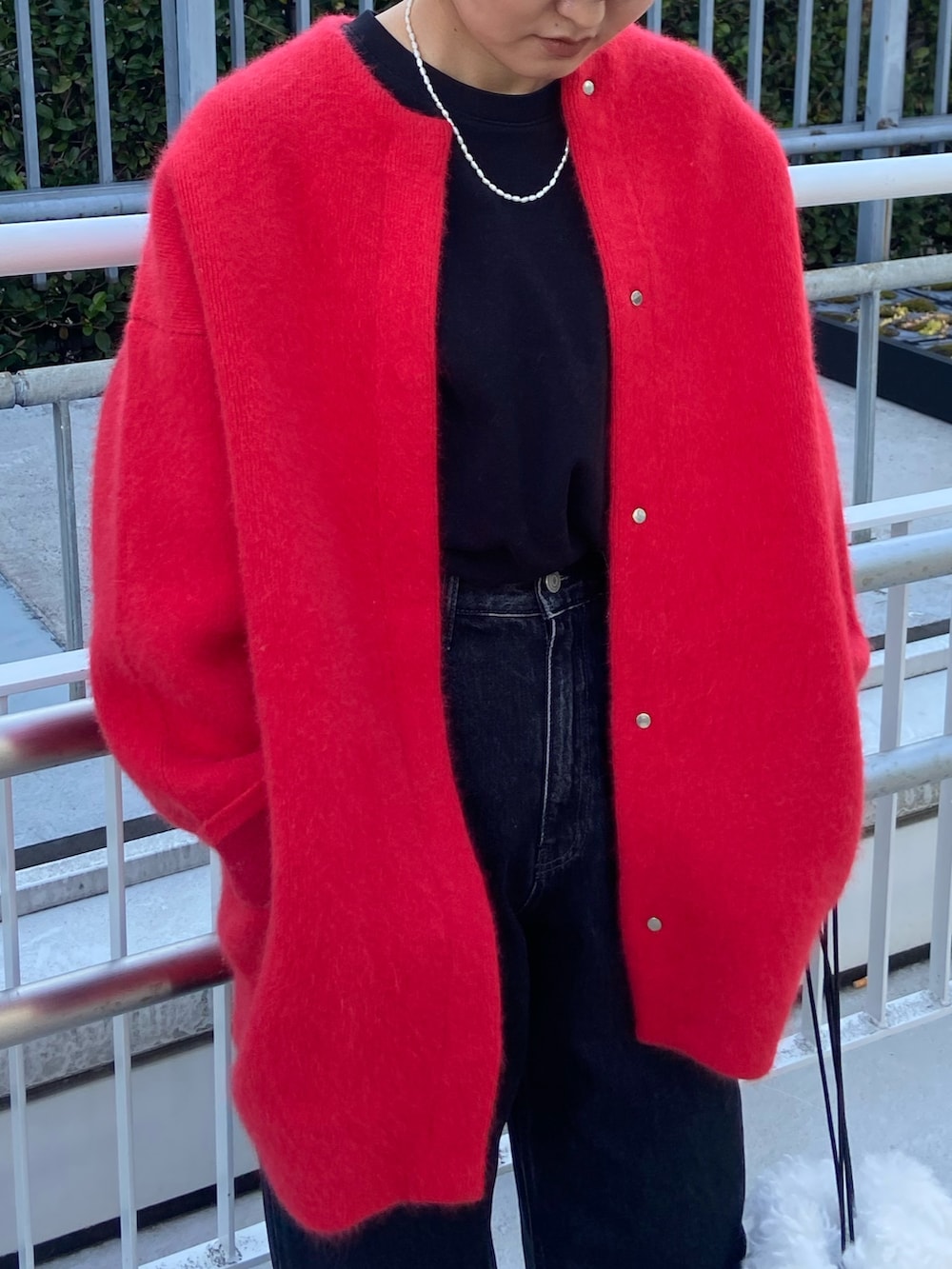 レッド系のカーディガン/ボレロ、ブラック系のデニムパンツ、ブラック系のブーツを着用したレディースの冬コーディネートの4枚目の写真