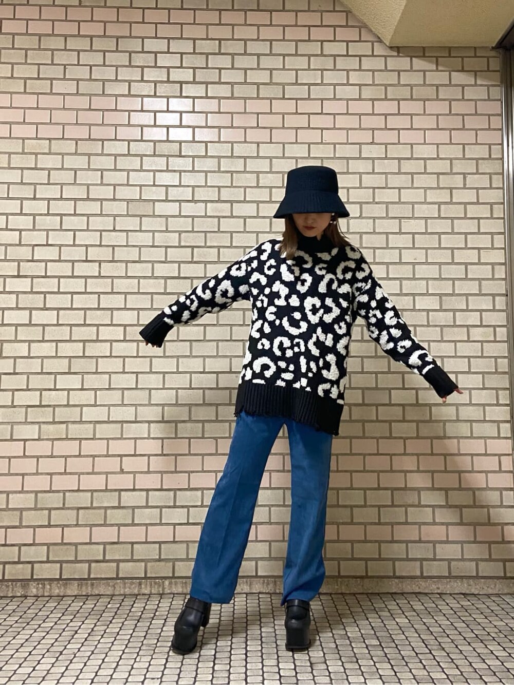 ブルー系のその他パンツ、ブラック系のニット/セーター、ブラック系のローファーを着用したレディースの冬コーディネートの2枚目の写真