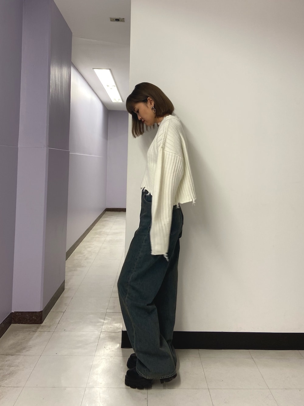 ホワイト系のニット/セーター、ブルー系のデニムパンツ、ブラック系のブーツを着用したレディースの秋コーディネートの2枚目の写真