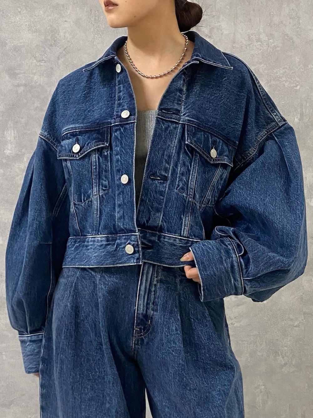 ブルー系のデニムジャケット、シルバー系のキャミソール、ブルー系のデニムパンツを着用したレディースの春コーディネートの5枚目の写真