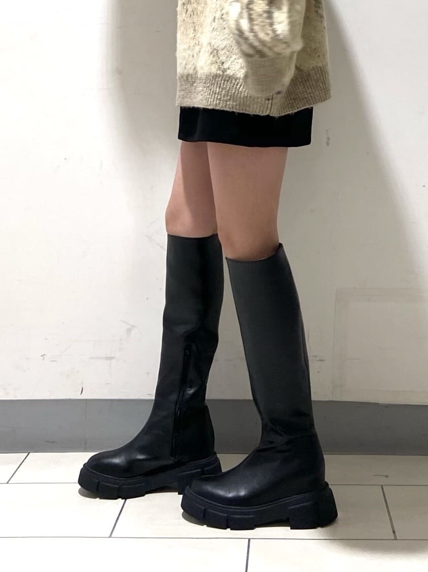 ブラック系のブーツ、ブラック系のスカート、ブラック系のニット/セーターを着用したレディースの冬コーディネートの5枚目の写真