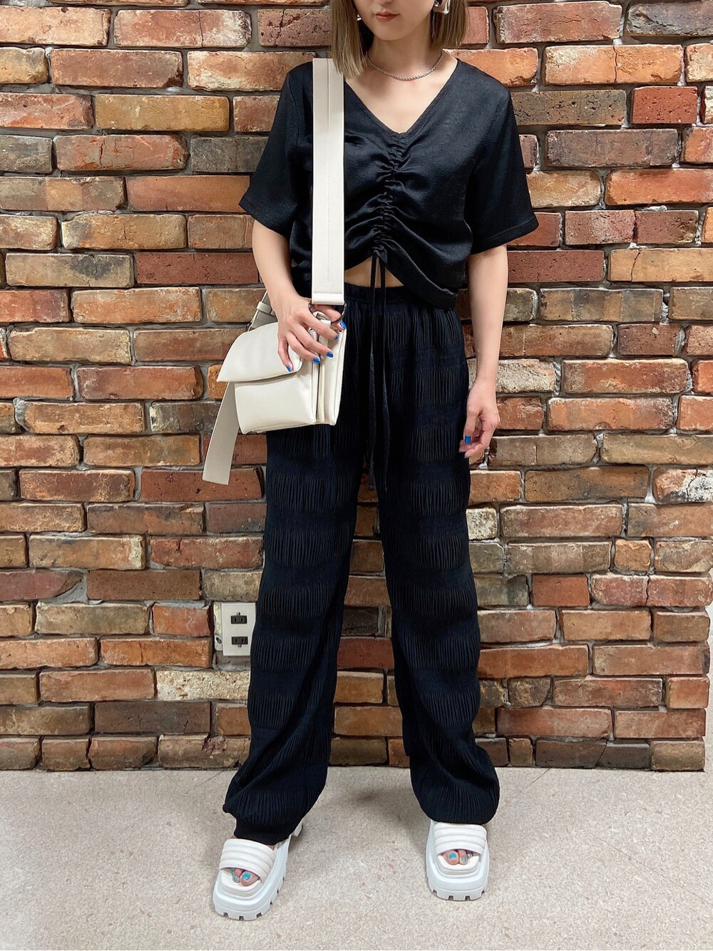 ブラック系のその他パンツ、ホワイト系のショルダーバッグ、ブラック系のTシャツ/カットソーを着用したレディースの春コーディネートの4枚目の写真