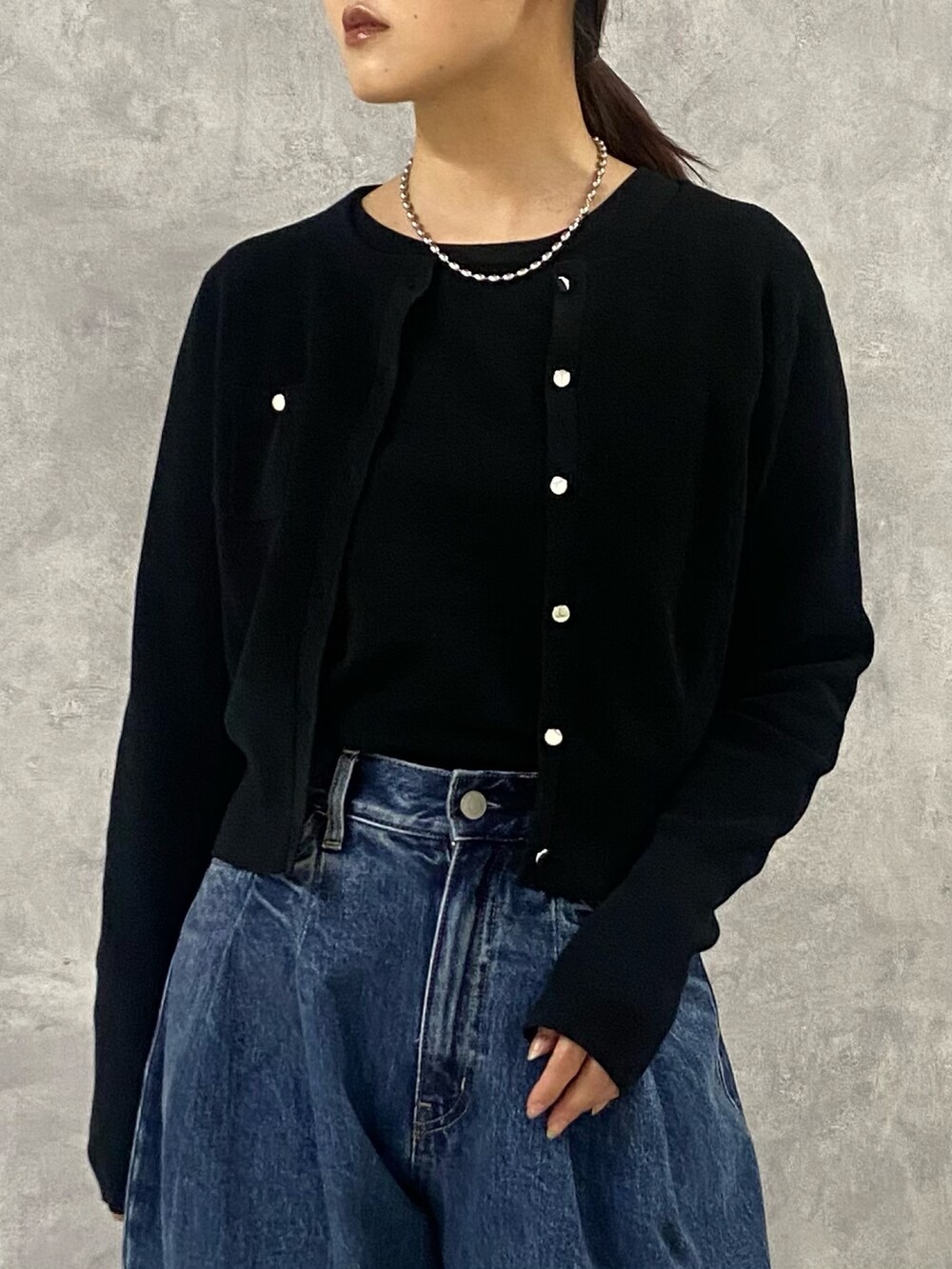 ブラック系のカーディガン/ボレロ、ブルー系のデニムパンツ、ブラック系のサンダルを着用したレディースの春コーディネートの4枚目の写真